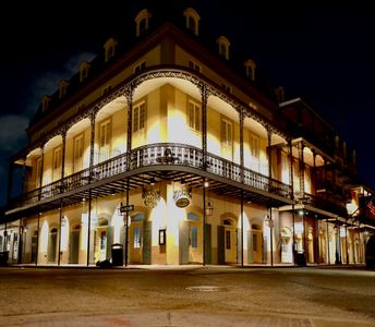 Warmly illuminated corner building in the New Orleans French Quarter at night